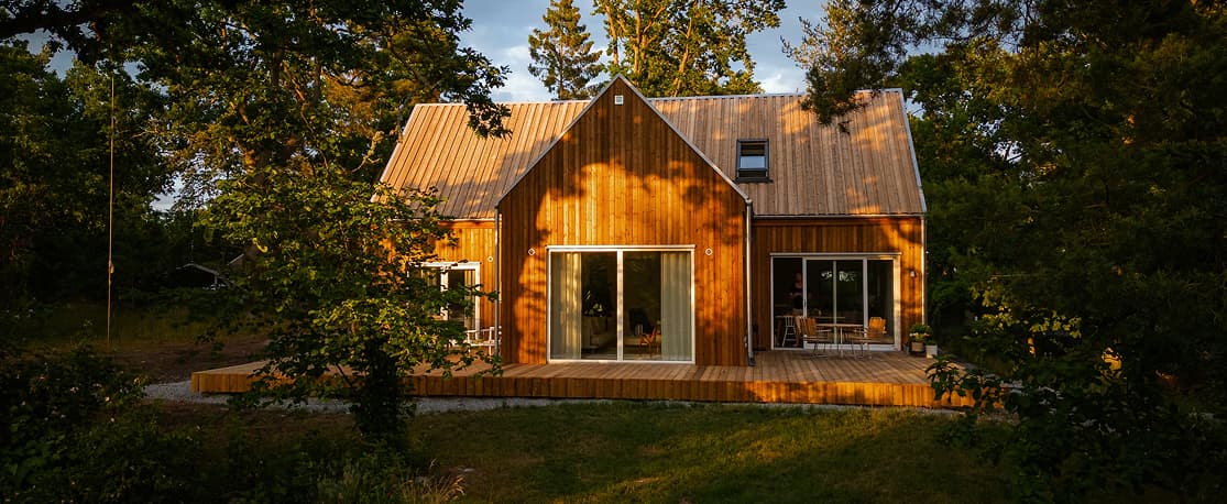 Maison en bois avec terrasse entourée de verdure